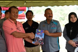 Pengarah Penerangan Negeri menyampaikan buku Dasar-Dasar Kerajaan kepada Ketua Pengarah Jabatan Pendaftaran Negara, Dato Ruslin Jusoh.