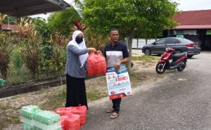 Pegawai Penerangan Daerah Dungun menyampaikan bubur lambuk kepada Pengerusi Perumahan Paya Lawas, Bukit Besi bagi diedarkan kepada penduduk setempat.