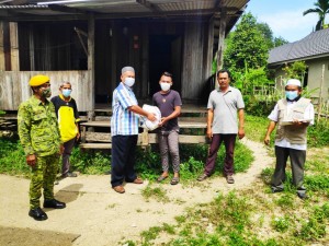 Wakil MPKK, Kampung Binjai Manis, Mustafa Abdullah menyerahkan kit Aidilfitri kepada penerima.