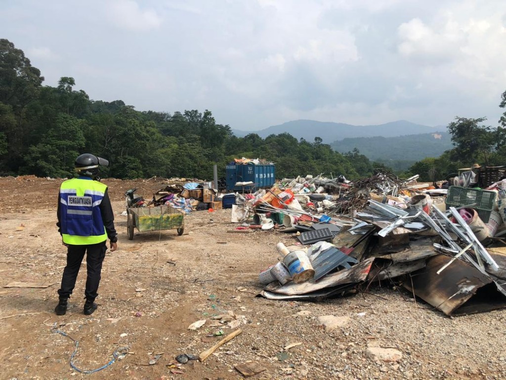 Kelihatan Penguatkuasa MPS memerhati sebuah lori membawa sampah ke tapak pelupusan sampah haram melarikan diri daripada dikenakan tindakan di Kampung Sungai Pusu, hari ini.