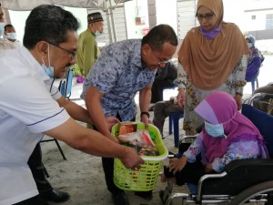 Menteri Besar Terengganu, Ahmad Samsuri diiringi isteri dan Pegawai Daerah Marang menyerahkan kunci rumah berserta barangan keperluan asas kepada penghuni Taman Rahmat, Puteh Embong.