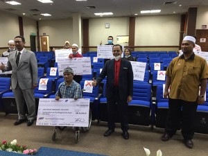 Mohd Nurkhuzani Ab Rahman bergambar bersama wakil penerima-penerima Tabung Usahawan Sejahtera (TUGAS) dan Tabung Pemulihan PKS COVID-19.