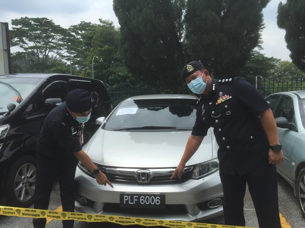 Arifai (kanan) menunjukkan kereta mewah yang dicuri Geng Ah Yong menggunakan nombor pendaftaran palsu.