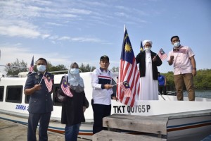 Pengarah Penerangan Negeri Terengganu, Azahar Ismail dan Penyelaras DUN Permaisuri, Zul Bhari Abdul Rahman memacak Jalur Gemilang di bot sebagai simbolik program Merdeka @ Komuniti di Jeti Merang, Setiu.