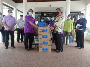 Ahmad Razif menyerahkan sumbangan barangan keperluan harian PUS di Pusat Kuarantin BTP kepada Pegawai Daerah Marang.