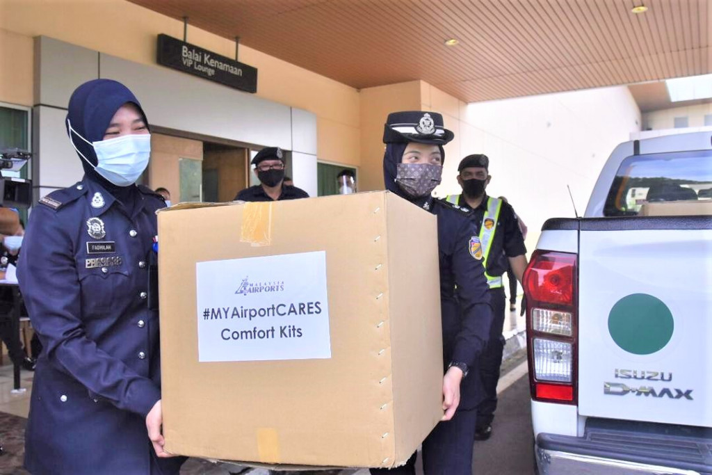Inspektor Dayang Noorhadizah Nasip (kanan) dibantu anggotanya Konstabel Noorfadhilah Rahim mengangkat kotak kit keselesaan ke dalam kenderaan.