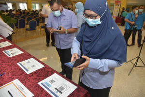 Tetamu jemputan mengimbas QR Code My Sejahtera ketika sesi pendaftaran. 