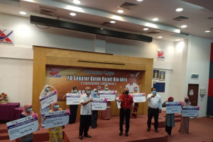 Pengerusi Ketengah, Senator Datuk Razali Idris (baju merah) bergambar kenang-kenangan bersama pelajar-pelajar yang menerima tajaan.
