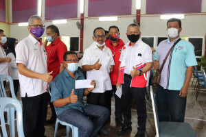 Pengerusi Ketengah Datuk Razali Idris (dua dari kanan) bersama ADUN Bukit Besi, Roslee Daud bergambar dengan salah seorang penerima sumbangan.