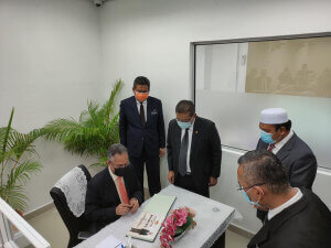 Menteri di Jabatan Perdana Menteri (Parlimen dan Undang-undang) Datuk Takiyuddin Hassan menandatangani buku lawatan kerja sambil di perhatikan oleh Ahli Parlimen Setiu dan Pegawai Daerah Setiu.
