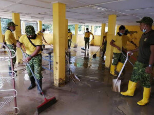 Anggota RELA menjalankan kerja-kerja pembersihan pasca banjir.