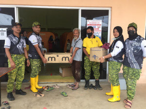 Pegawai Rela Daerah Dungun, Mohd Syuhari Abdan (dua dari kiri) menyerahkan sumbangan bencana banjir kepada Pengerusi JPKK Kampung Pasir Raja, Tengku Mat Yunus Tengku Mat Rani bagi kegunaan penduduk yang terjejas.