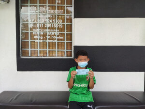 Muhammad Alif Naufal Mazlam, 9, gembira dapat bersama kawan-kawan menggunting rambut.