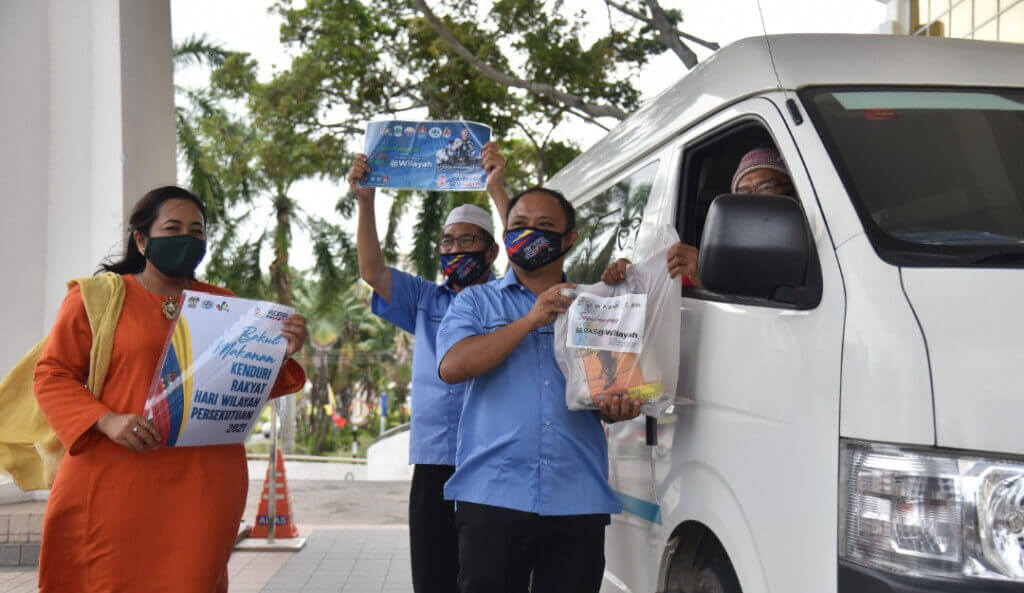 Pengerusi MPPWP Labuan Dzulfaizal Ab Manan (tengah) menyerahkan MyBeras@Wilayah kepada salah seorang Pengerusi MPPWP Sub Zon.
