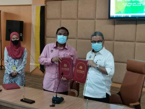 Rumaizi Baharin (kanan) dan wakil Perbadanan Pembangunan Pertanian Negeri Perak (PPPNP), Yahanis Yahya menunjukkan MoU yang telah ditandatangani.