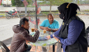 Petugas lapangan mengedarkan bahan penerbitan kepada orang ramai.