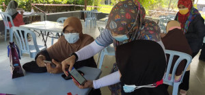 Petugas IOW JaPen membantu warga emas cara pendaftaran secara digital.