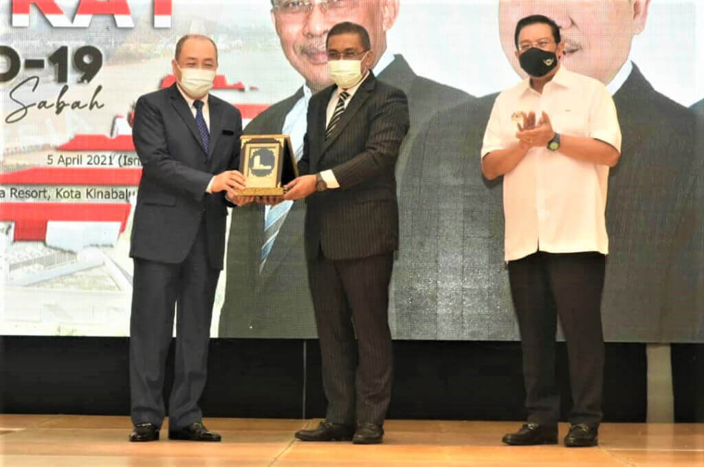 Takiyuddin (tengah) menyampaikan cenderamata kepada Hajiji (kiri) sambil disaksikan Zuki (kanan).