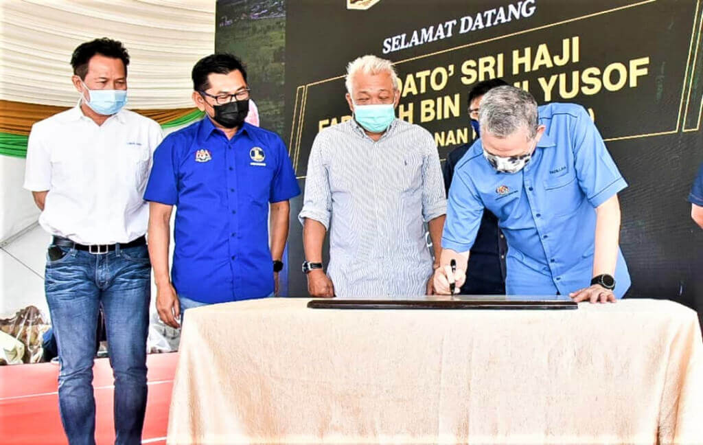 Fadillah (kanan) menandatangani plak sambil diperhatikan oleh Bung (tengah), Mohamad dan Limus (kiri).
