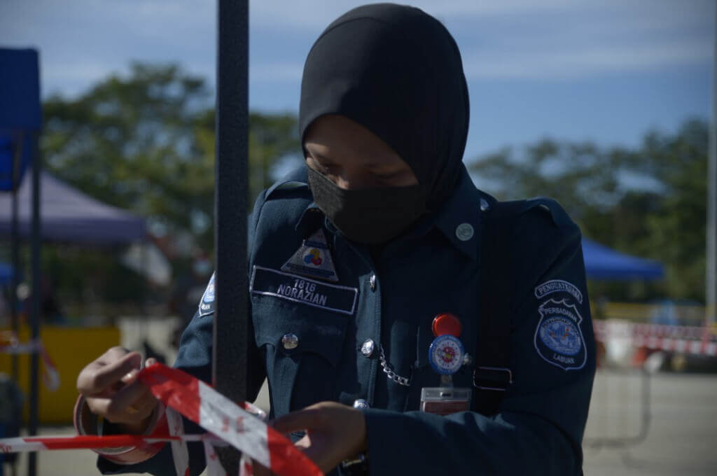 Seorang anggota penguatkuasa Perbadanan Labuan memasang pita keselamatan untuk kemudahan para pengunjung.
