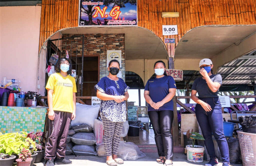 Silis (dua dari kiri) bersama anak-anak buah yang membantunya mengusahakan perniagaannya.