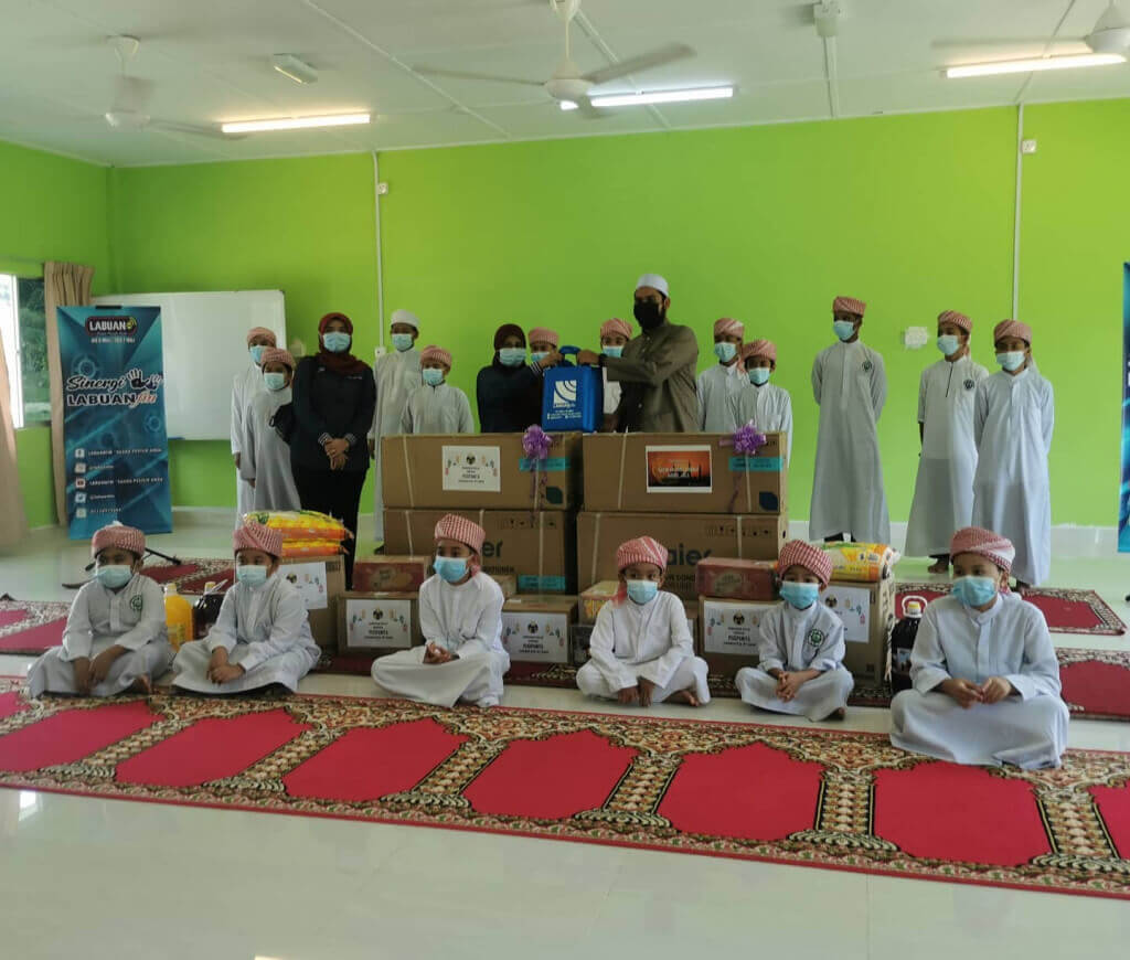 Aminah (berdiri dua dari kiri) menyampaikan sumbangan kepada Maahad Tahfiz Al Quran Al Badr.