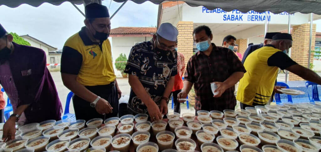 (Dua dari kiri) Timbalan Menteri Pendidikan I, Muslimin Yahaya turut serta rewang@PMR menyediakan juadah bubur lambuk.