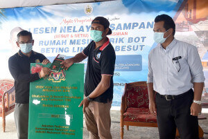 Dr. Azman menyerahkan lesen sampan kepada seorang nelayan.