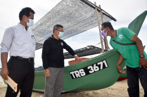 Dr. Azman (tengah) berbual dengan nelayan yang menerima lesen sampan di Kampung Beting Lintang, Besut.