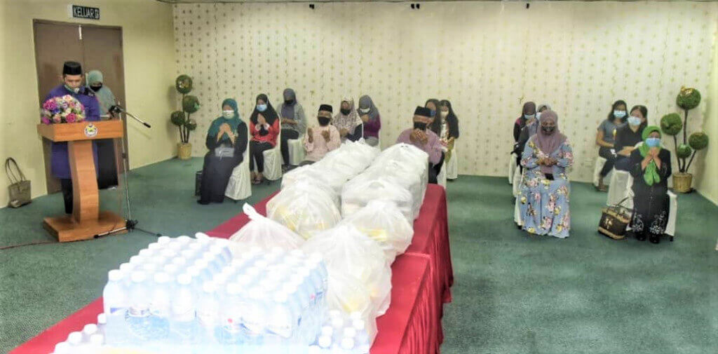 MOHON KEBERKATAN... Bacaan doa selamat yang dipimpin Ustaz Hamzah Ahmad sebelum majlis penyerahan sumbangan bermula.