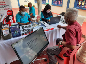 Kakitangan Pejabat Penerangan Daerah Barat Daya membuka kaunter pendaftaran vaksinasi kepada para hadirin.