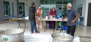 Pembungkusan bubur lambuk 'gearbox' turut dibantu golongan muslimah di Masjid Al-Mustaghfirin Sungai Tiram.