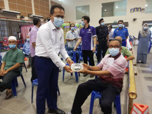 Wan Ismail Wan Chik, 74 (kanan) dari Kampung Beladau Kepong antara penerima vaksin di sini turut menerima juadah berbuka puasa.
