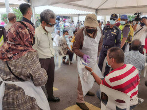 Menteri Wilayah Persekutuan, Tan Sri Annuar Musa beramah mesra bersama bakal penerima vaksin semasa Program Projek Rintis Trak Vaksin Bergerak MYMedic@Wilayah.