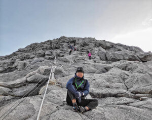 Aziem merakamkan gambar kenangan berhampiran puncak Gunung Kinabalu ketika menunggu giliran untuk naik ke puncak Low's peak.