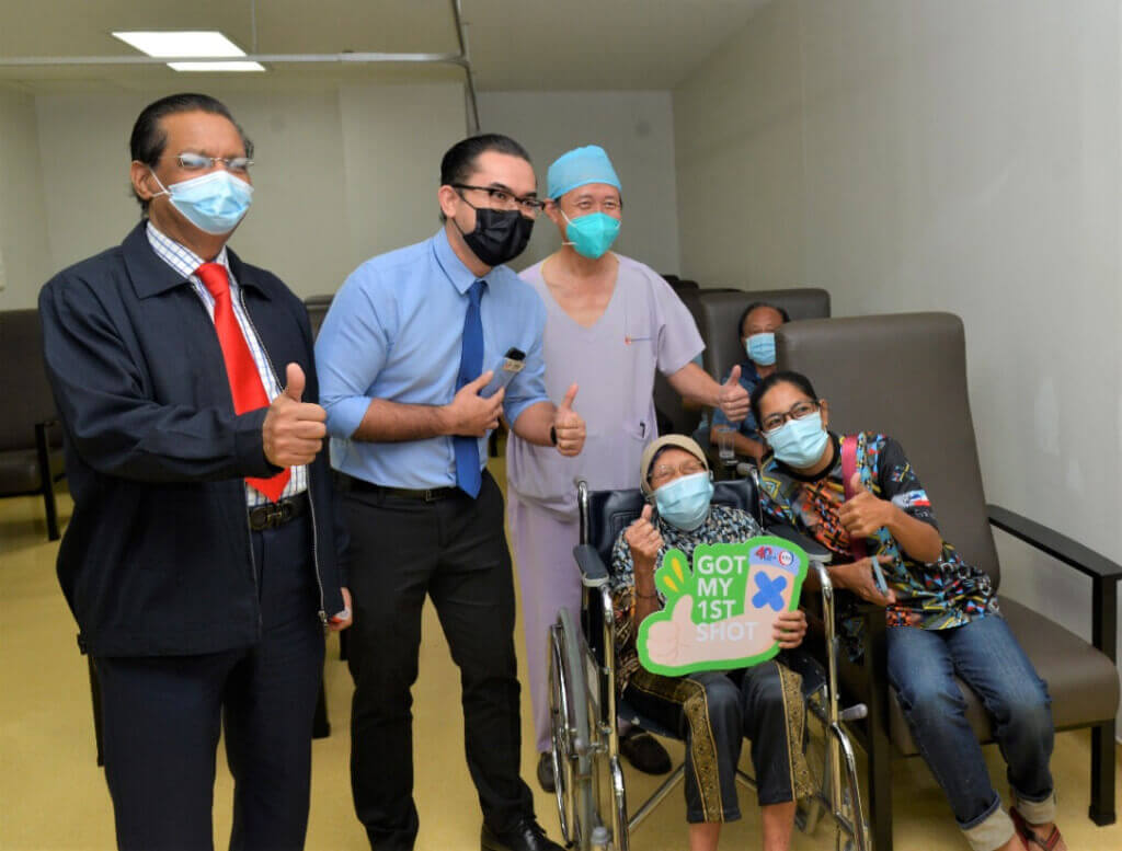 Ajaz (kiri), Faizal (dua dari kiri) dan Lim (tiga dari kiri) merakamkan gambar kenangan bersama salah seorang penerima vaksin, Annah Datu Asibih.