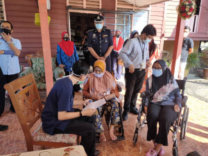 Zarina Abdul ketika mendengar penjelasan ringkas tentang vaksin COVID-19.