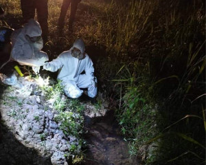 Pasukan HAZMAT sedang mengambil sampel air sungai yang tercemar akibat salah satu tangki bahan kimia tersebut pecah. 