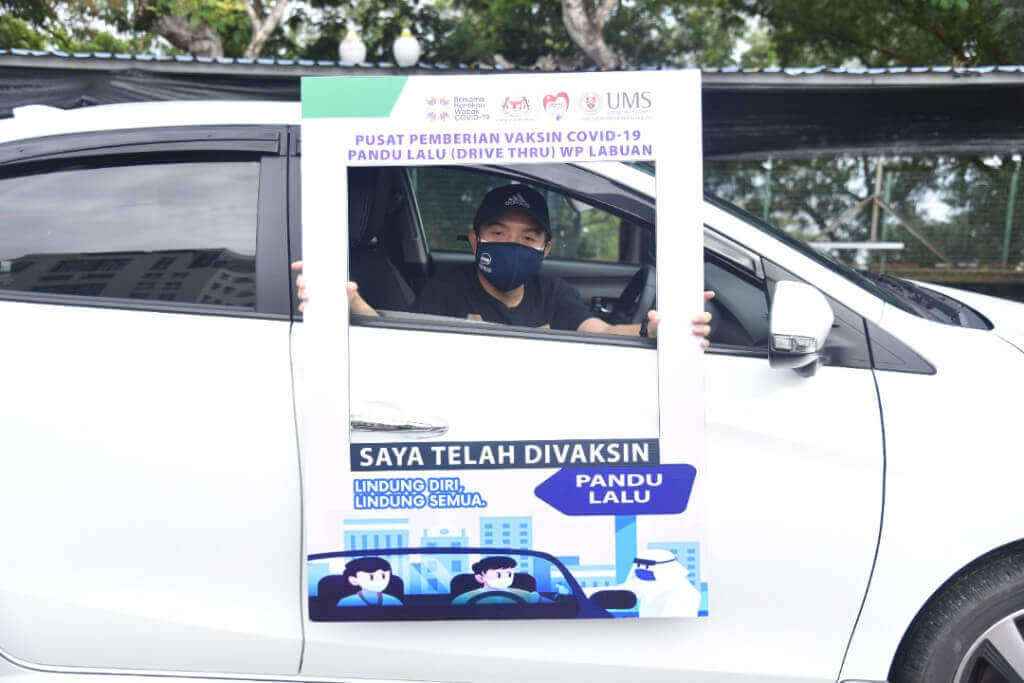 Salah seorang penerima vaksin COVID-19 merakamkan gambar kenangan.