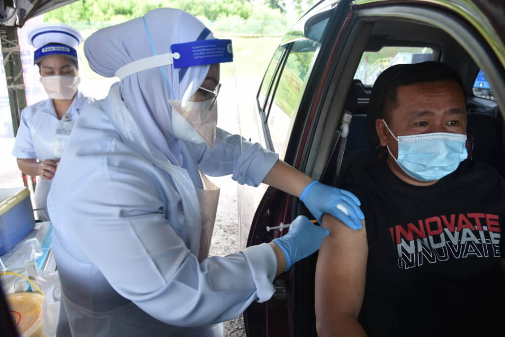 Petugas Kesihatan memberikan vaksin kepada salah seorang penerima.