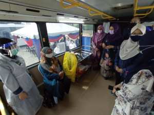 Datuk Halimah Mohamed Sadique melawat ke dalam bas MOVAK bagi melihat proses suntikan vaksin. 