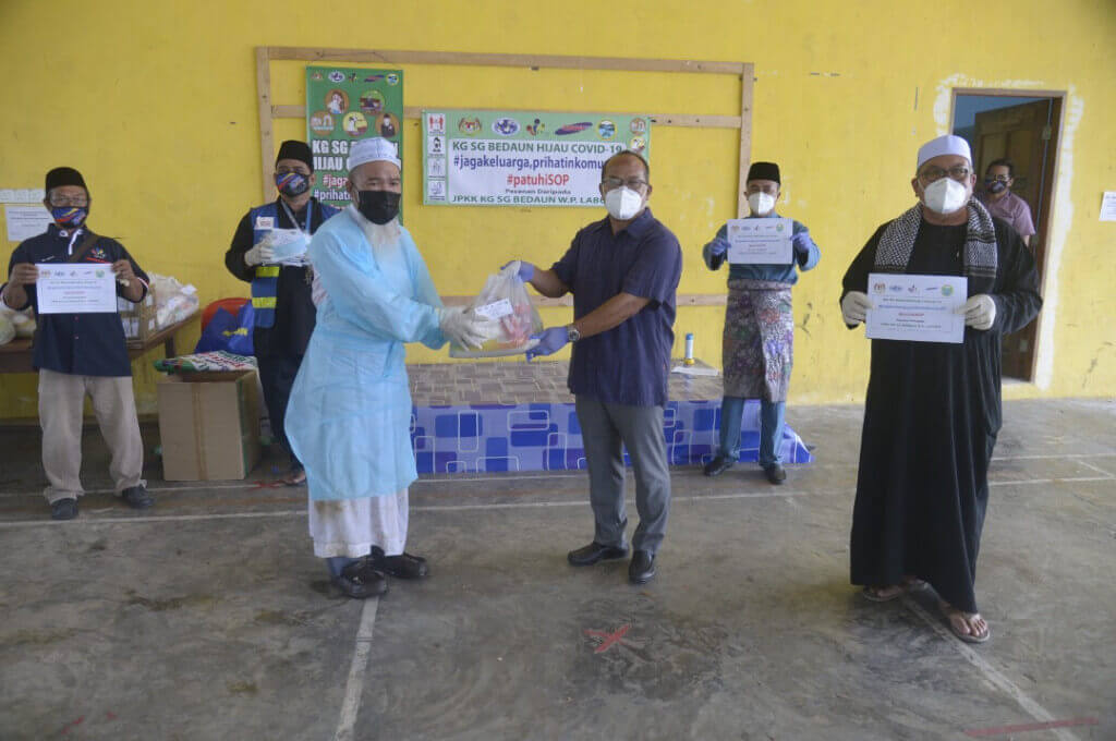 Bashir (tiga dari kanan) menyampaikan bakul makanan kepada petugas majlis korban.