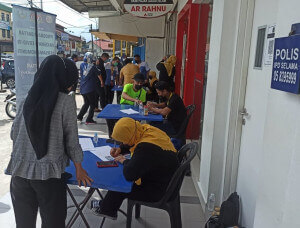 Sesi pendaftaran vaksinasi oleh wakil ROS Perak kepada penduduk di sekitar Pekan Selama di hadapan bangunan Agrobank Selama.