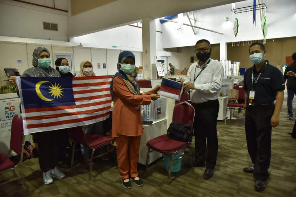 Pengarah Japen Selangor (kanan) menyampaikan jalur gemilang kepada petugas kesihatan PKRC bersepadu MAEPS 2.0 yang terlibat.