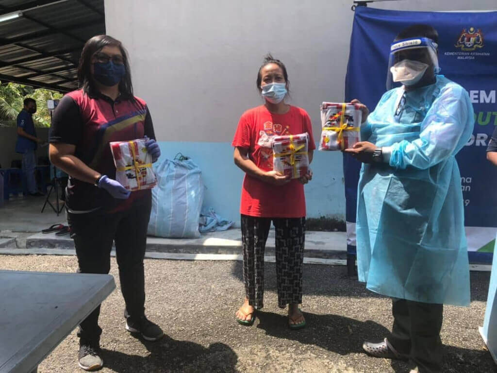 Noor Sazarina Mohd Noor, wakil Pegawai Penerangan Daerah Hulu Langat menyerahkan Jalur Gemilang kepada Uni Sudah, Pengerusi Jawatankuasa Pembangunan dan Keselamatan Kg. Orang Asli Kachau Dalam disaksikan oleh Mohd Nor Waakub, wakil Pegawai JAKOA Daerah Hulu Langat.