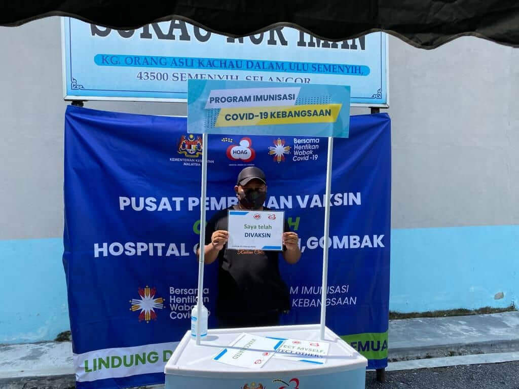 Salah seorang penduduk Kg Kachau Dalam selepas divaksin tidak melepas peluang bergambar kenangan.
