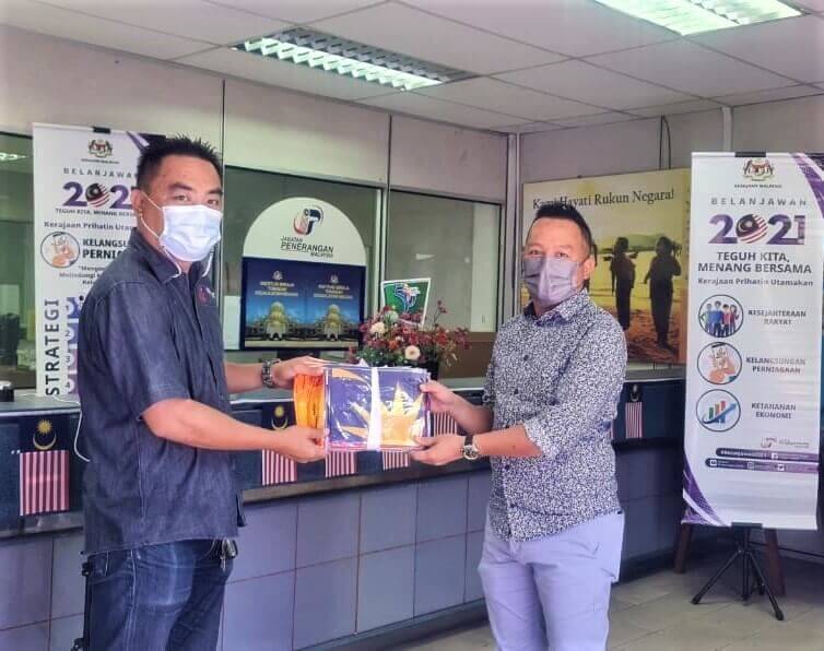 RAKAN STRATEGIK... Pembantu Penerangan, Stephen Jipolin Jouti (kiri) mewakili Zaidi menyampaikan Jalur Gemilang kepada Ketua UPPM Tanjung Aru, Riduan Datuk Aklee (kanan).