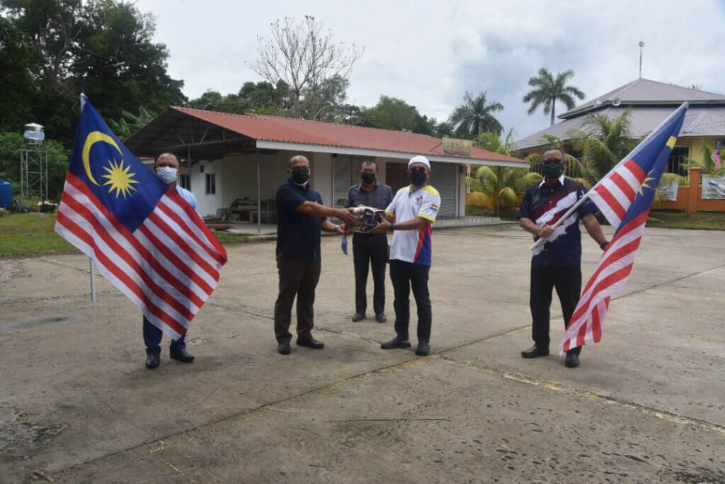 Bashir menyampaikan Jalur Gemilang kepada Ketua Kampung Pantai mewakili SubZon 1.