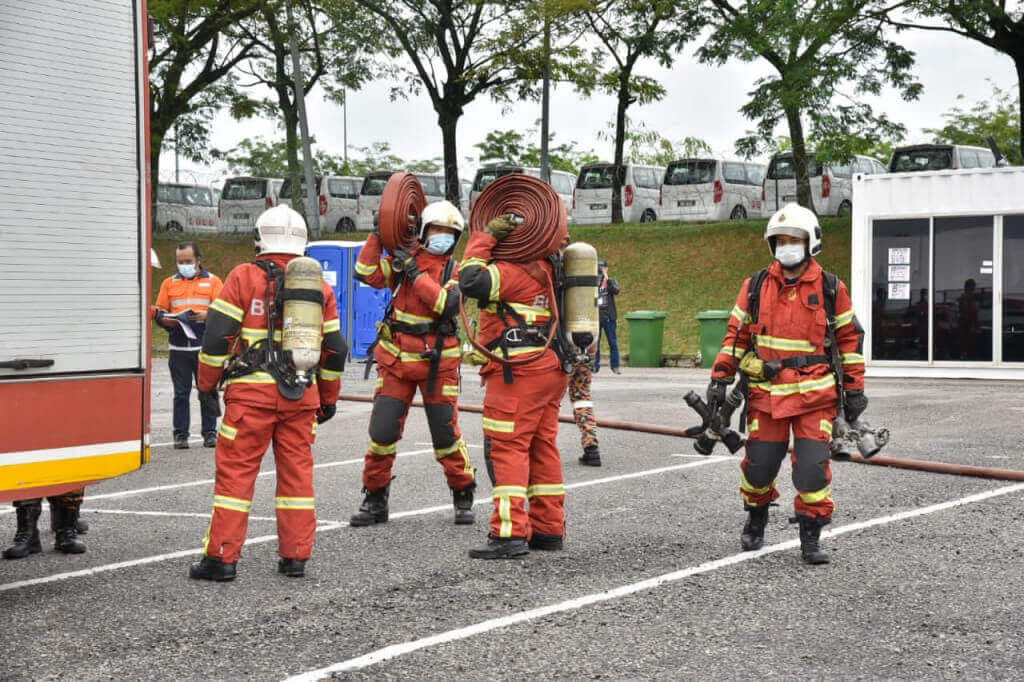 Beberapa anggota bomba menyediakan peralatan pemadam kebakaran ketika latihan dijalankan.