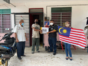 Encik Khairul Nizam Khairuddin menyerahkan kotak Rezeki Ummat kepada keluarga yang memerlukan.
